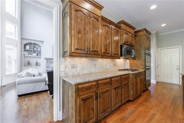 652 Pathview Ct, Dacula, GA 30019 - kitchen featuring appliances with stainless steel finishes, dark wood finished floors, crown molding, plenty of natural light, and decorative backsplash