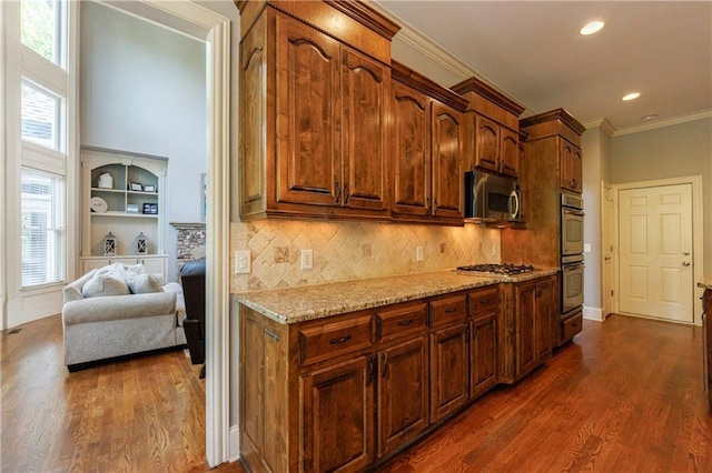 652 Pathview Ct, Dacula, GA 30019 - kitchen featuring appliances with stainless steel finishes, dark wood-type flooring, crown molding, light stone countertops, and tasteful backsplash