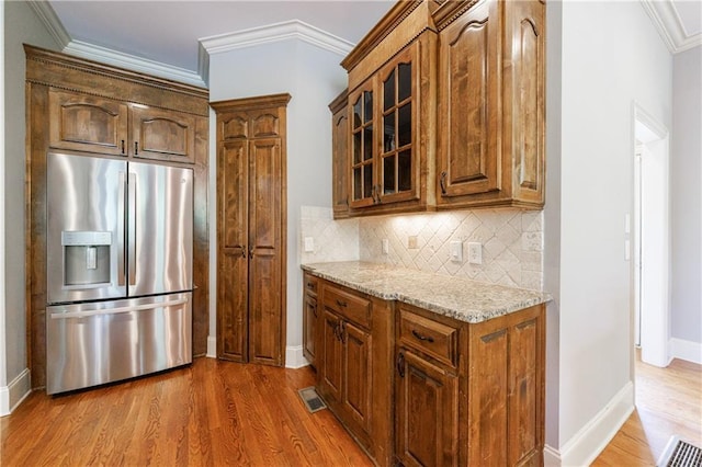 652 Pathview Ct, Dacula, GA 30019 - kitchen featuring stainless steel fridge with ice dispenser, wood finished floors, glass insert cabinets, light stone counters, and decorative backsplash