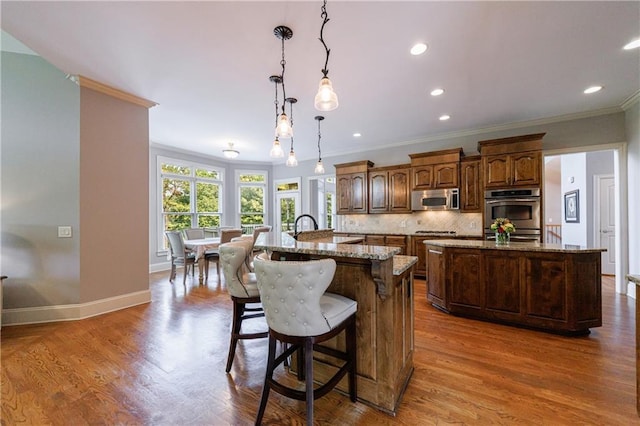 652 Pathview Ct, Dacula, GA 30019 - kitchen featuring stainless steel appliances, an island with sink, crown molding, tasteful backsplash, and baseboards