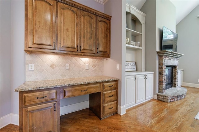 652 Pathview Ct, Dacula, GA 30019 - unfurnished office with light wood-type flooring, built in desk, a fireplace, and baseboards