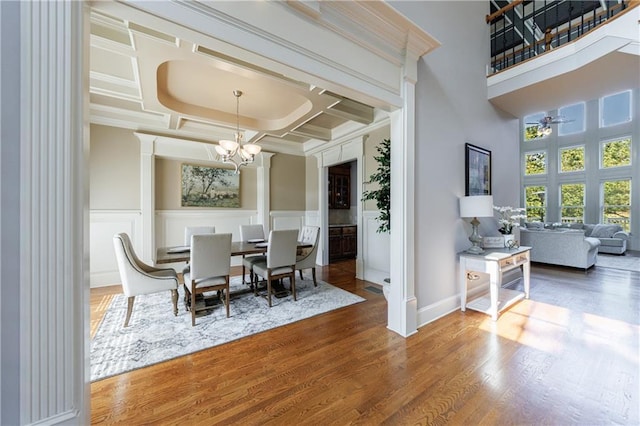 652 Pathview Ct, Dacula, GA 30019 - dining area with a chandelier, coffered ceiling, a decorative wall, wood finished floors, and a ceiling fan