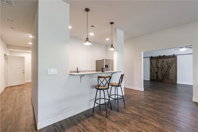 652 Pathview Ct, Dacula, GA 30019 - kitchen featuring stainless steel fridge, a barn door, dark wood-type flooring, a kitchen breakfast bar, and recessed lighting
