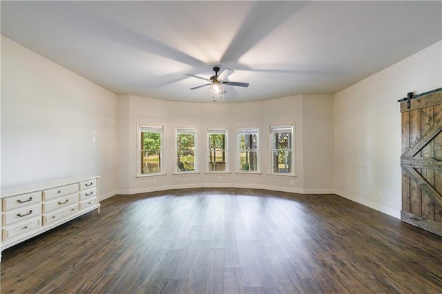 652 Pathview Ct, Dacula, GA 30019 - unfurnished living room featuring a barn door, plenty of natural light, a ceiling fan, and dark wood-style flooring