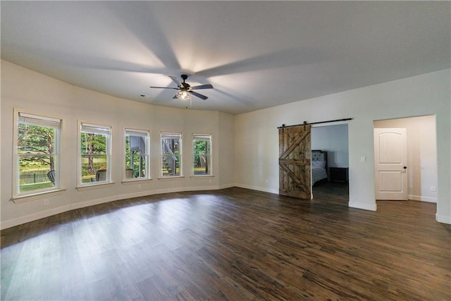 652 Pathview Ct, Dacula, GA 30019 - spare room featuring a barn door, a ceiling fan, dark wood-style floors, and baseboards