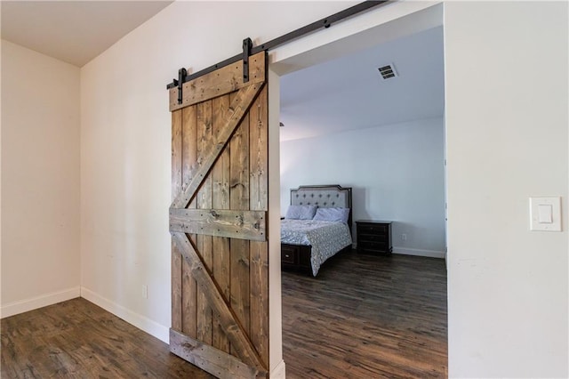 652 Pathview Ct, Dacula, GA 30019 - unfurnished bedroom with a barn door, dark wood-style floors, and baseboards