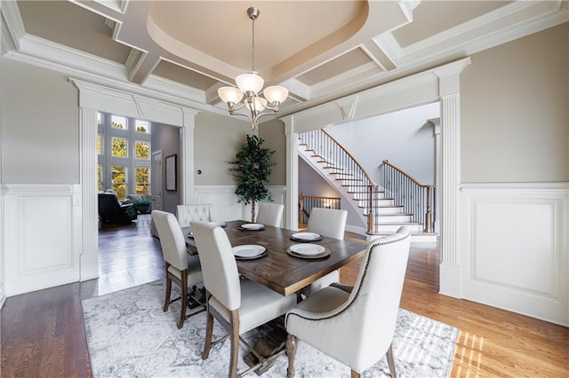 652 Pathview Ct, Dacula, GA 30019 - dining room with a chandelier, coffered ceiling, decorative columns, stairs, and a wainscoted wall