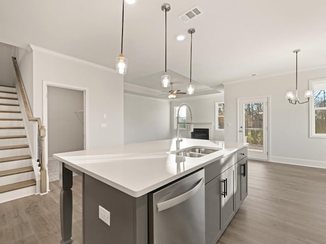 kitchen featuring ornamental molding, sink, dishwasher, and a kitchen island with sink