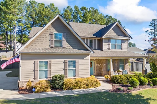 craftsman-style house featuring covered porch and a front lawn