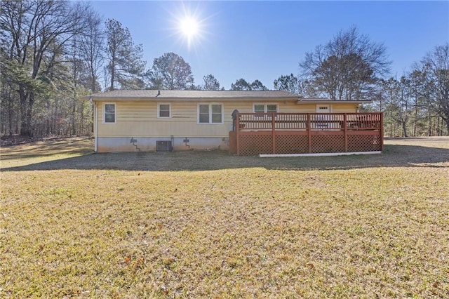 back of property featuring a deck, cooling unit, and a lawn