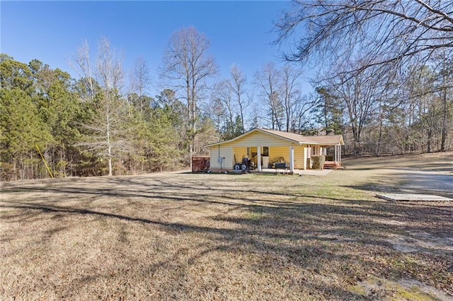 view of side of property with covered porch and a yard