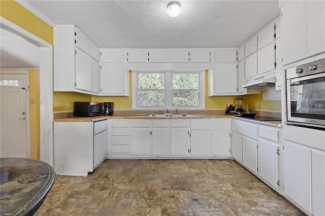 kitchen with white cabinets, a textured ceiling, sink, and black appliances