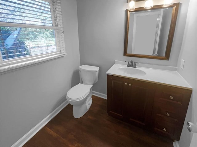 bathroom featuring vanity, toilet, wood finished floors, and baseboards