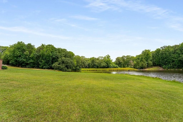 view of home's community featuring a lawn and a water view