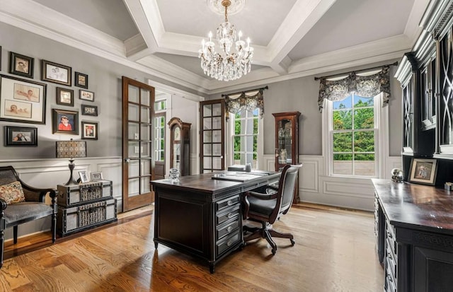 office space with coffered ceiling, french doors, light wood-type flooring, ornamental molding, and a chandelier