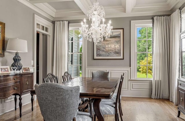 dining room featuring coffered ceiling, ornamental molding, a notable chandelier, beamed ceiling, and light hardwood / wood-style floors