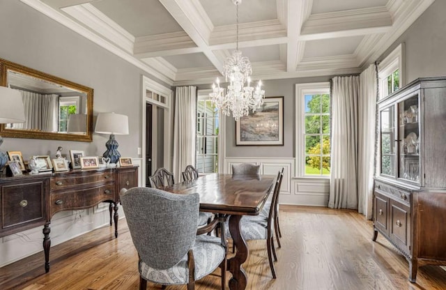 dining area featuring coffered ceiling, crown molding, beam ceiling, a notable chandelier, and light hardwood / wood-style floors