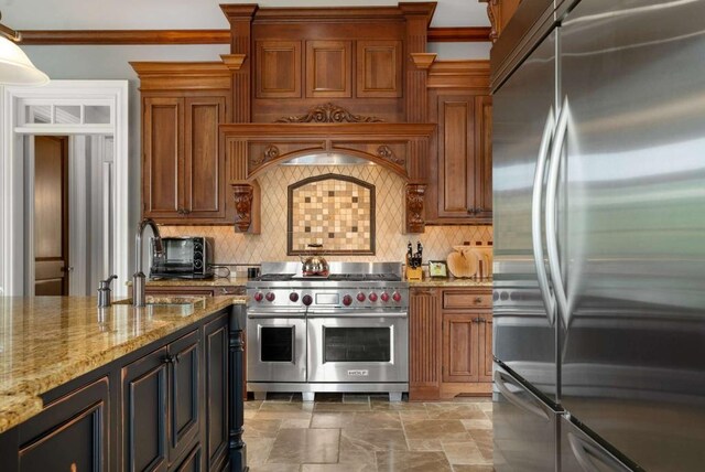 kitchen with sink, light stone counters, backsplash, appliances with stainless steel finishes, and ornamental molding