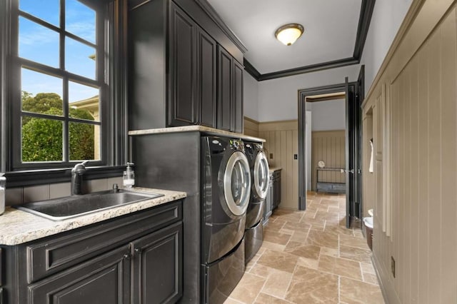 washroom featuring cabinets, sink, independent washer and dryer, and ornamental molding