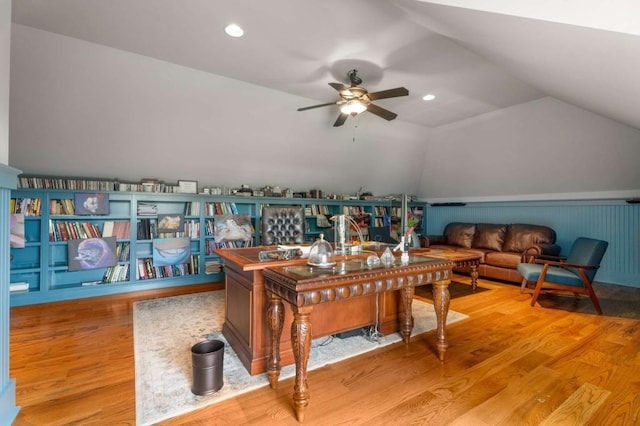 home office featuring ceiling fan, wood-type flooring, and vaulted ceiling