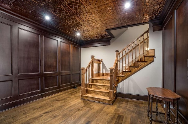 stairway featuring crown molding and hardwood / wood-style flooring