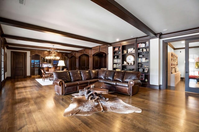 living room featuring built in shelves, dark hardwood / wood-style flooring, beamed ceiling, and a notable chandelier