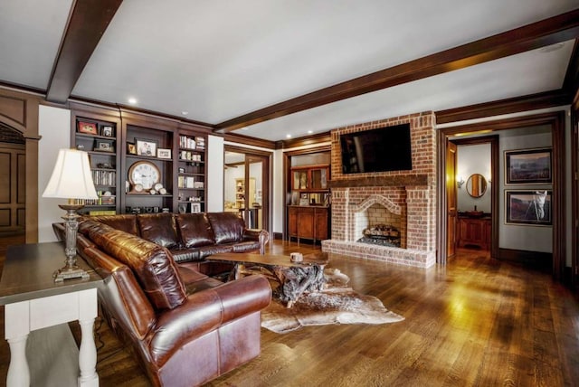 living room with built in features, beamed ceiling, crown molding, wood-type flooring, and a fireplace