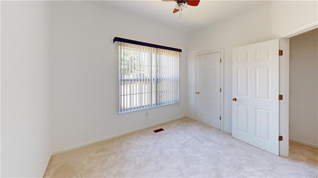 unfurnished bedroom featuring ceiling fan and light carpet