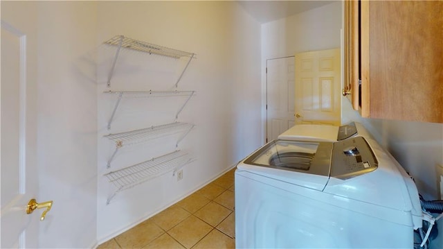 laundry room featuring light tile patterned floors, cabinets, and independent washer and dryer