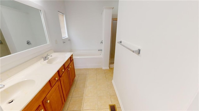 bathroom with tile patterned flooring, a bath, and vanity