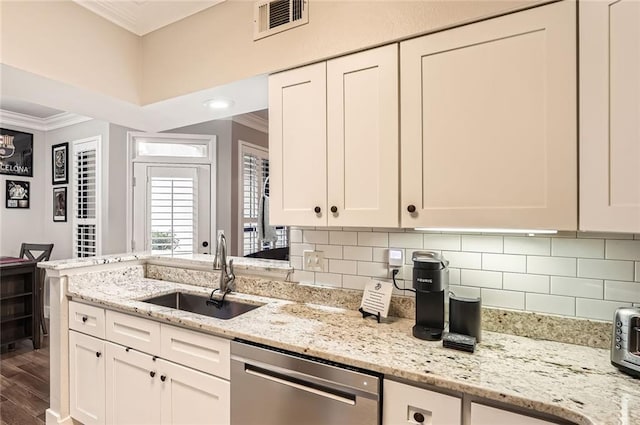 kitchen with visible vents, ornamental molding, white cabinets, a sink, and dishwasher