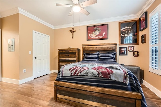 bedroom featuring a ceiling fan, baseboards, ornamental molding, and wood finished floors