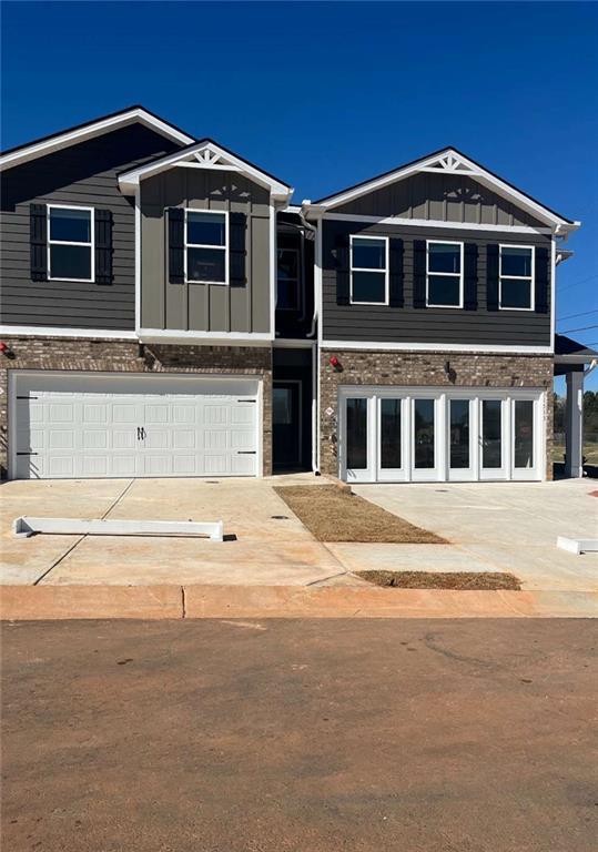 view of front of property featuring board and batten siding, concrete driveway, and a garage