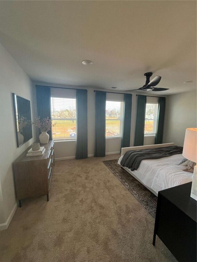 carpeted bedroom with a ceiling fan and baseboards