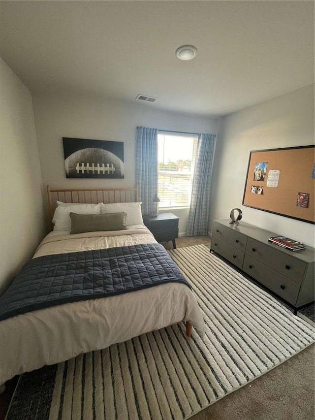 carpeted bedroom featuring visible vents