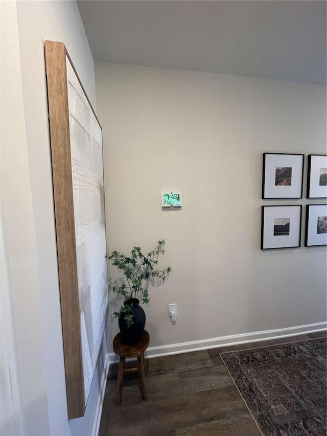 corridor with dark wood-style floors and baseboards