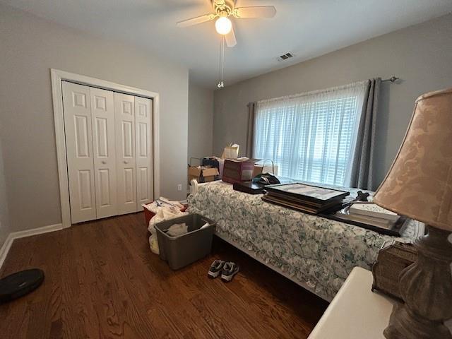bedroom featuring ceiling fan, visible vents, wood finished floors, and a closet