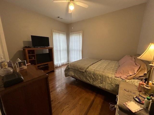 bedroom with visible vents, a ceiling fan, and dark wood finished floors