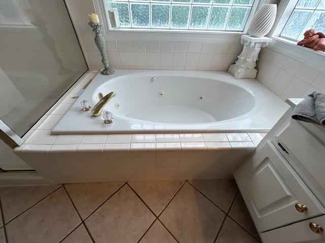full bathroom featuring a jetted tub and tile patterned floors