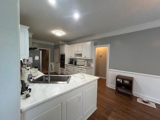 kitchen with freestanding refrigerator, black electric cooktop, ornamental molding, and a sink