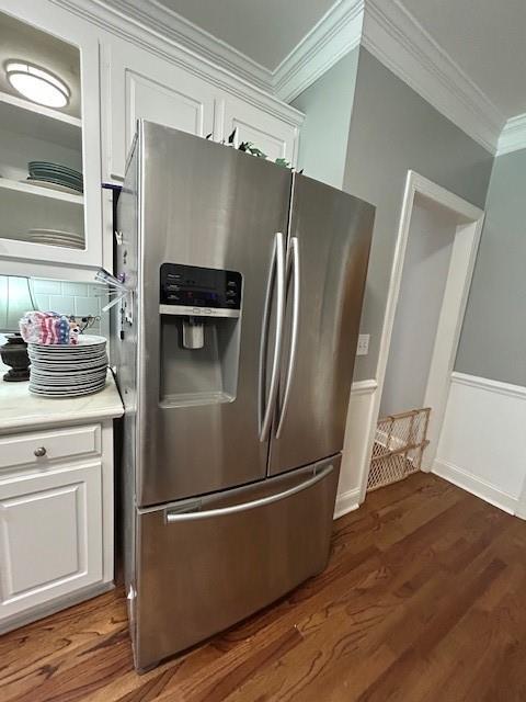 kitchen with stainless steel fridge with ice dispenser, light countertops, white cabinetry, backsplash, and ornamental molding