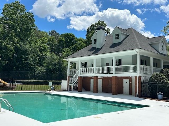 rear view of house featuring a patio, stairway, fence, and a fenced in pool