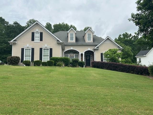 view of front facade with stucco siding and a front yard