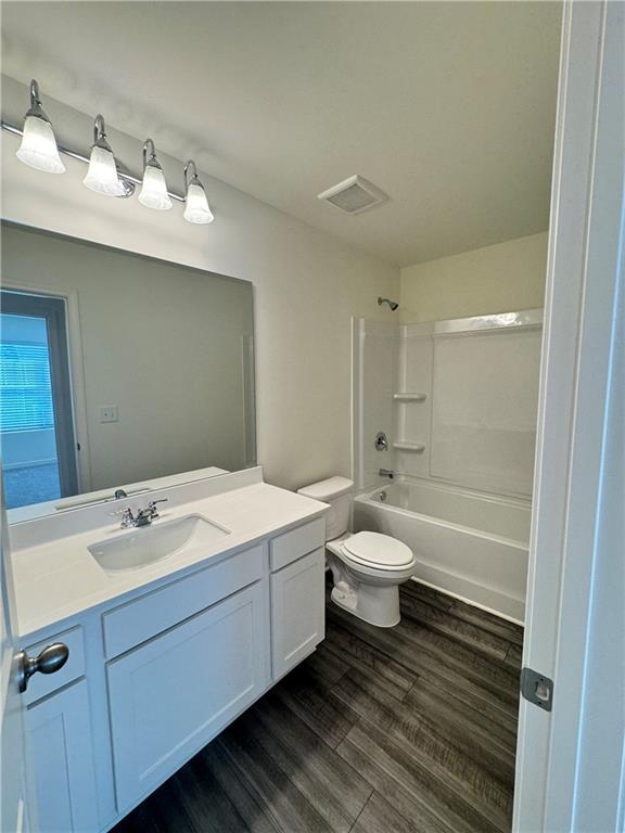 283 Rydal Way, Winder, GA 30680 - full bath featuring vanity, wood finished floors, and shower / tub combination
