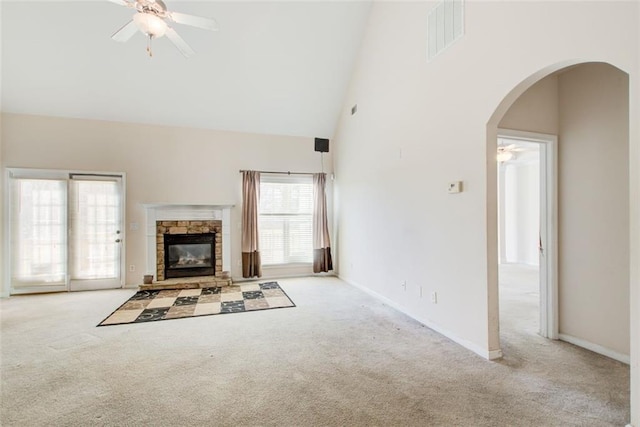 unfurnished living room with visible vents, carpet floors, high vaulted ceiling, arched walkways, and ceiling fan