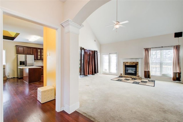 unfurnished living room featuring decorative columns, a ceiling fan, a wealth of natural light, and high vaulted ceiling