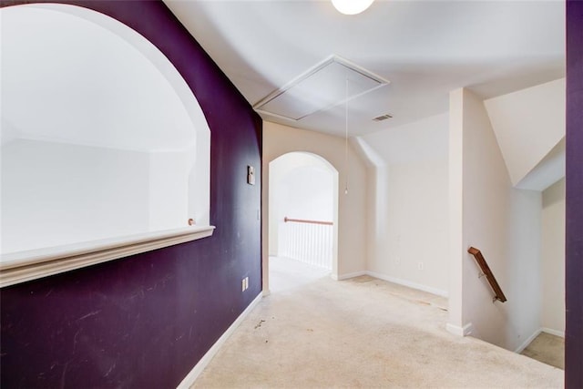 hallway featuring visible vents, an upstairs landing, carpet, attic access, and vaulted ceiling