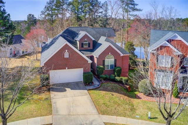 traditional-style house featuring a garage, a front lawn, brick siding, and driveway