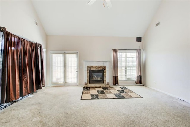 unfurnished living room with carpet flooring, a fireplace, high vaulted ceiling, and visible vents