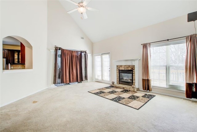 unfurnished living room with ceiling fan, a fireplace, carpet floors, and high vaulted ceiling